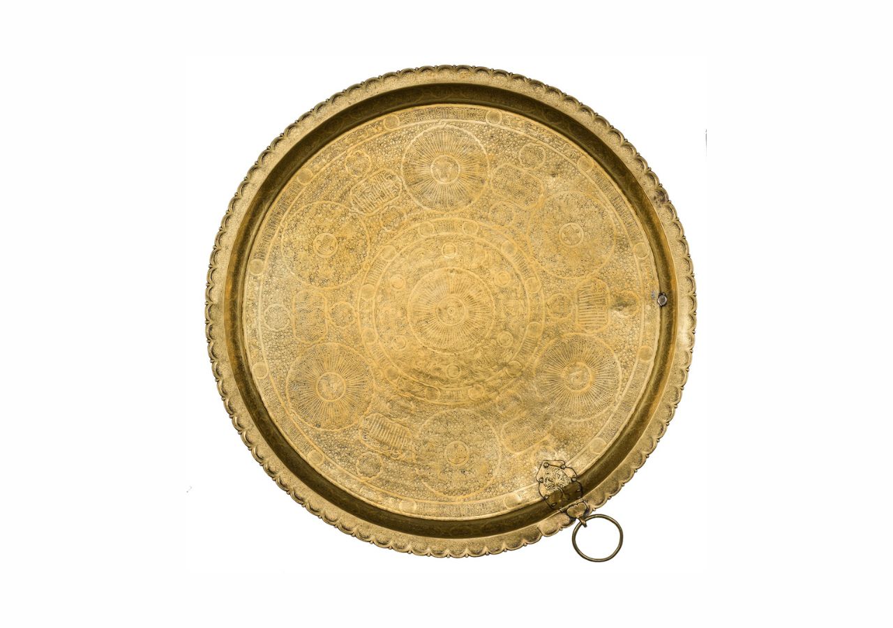 A serving tray crafted from hammered brass engraved and inlaid with gold from Egypt, Cairo or Syria that dates back to the Damascus Mamluk period, c. 1330-1341 CE