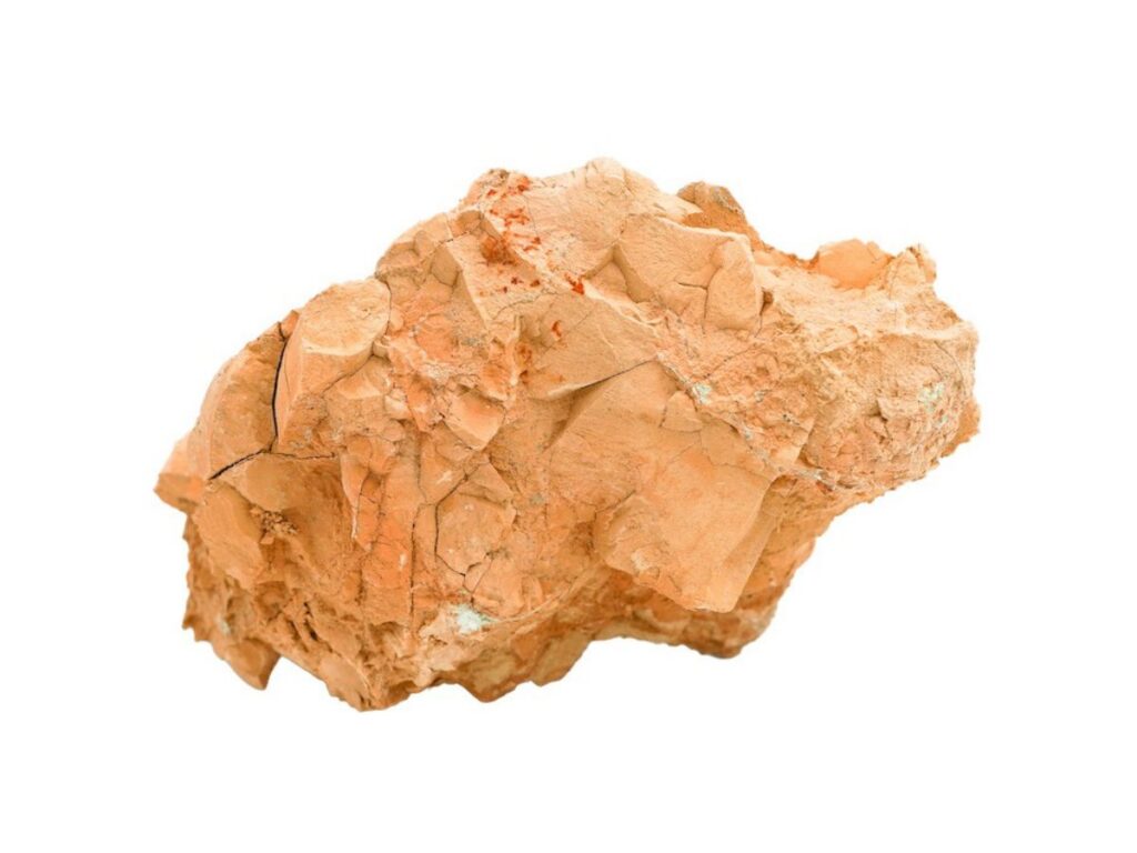 A rough, irregularly shaped piece of orange-brown clay rock with jagged edges and a textured surface, photographed by Abdulrahman Al Muftah and isolated on a white background.