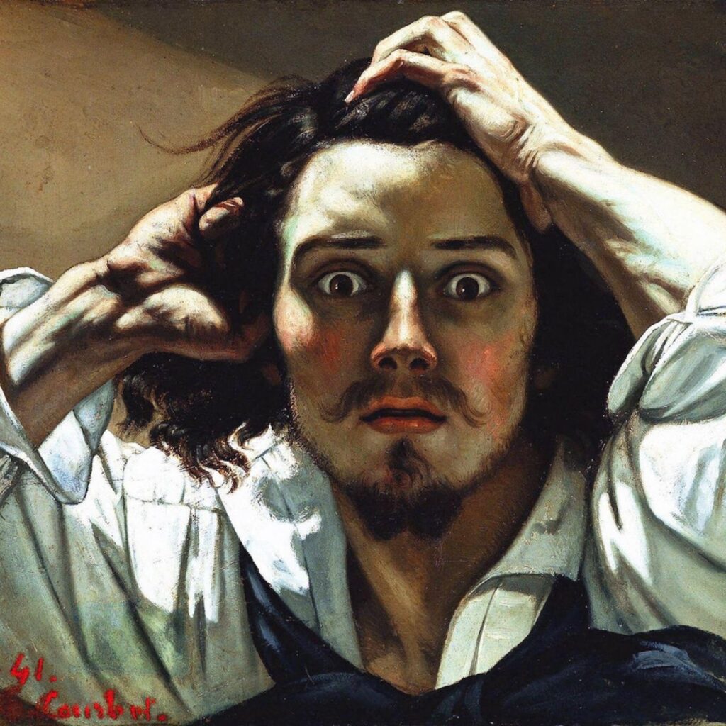 A striking portrait of a man with wide eyes and an anxious expression, clutching his long dark hair with both hands. He has a mustache, goatee, and wears a white shirt with an open collar.