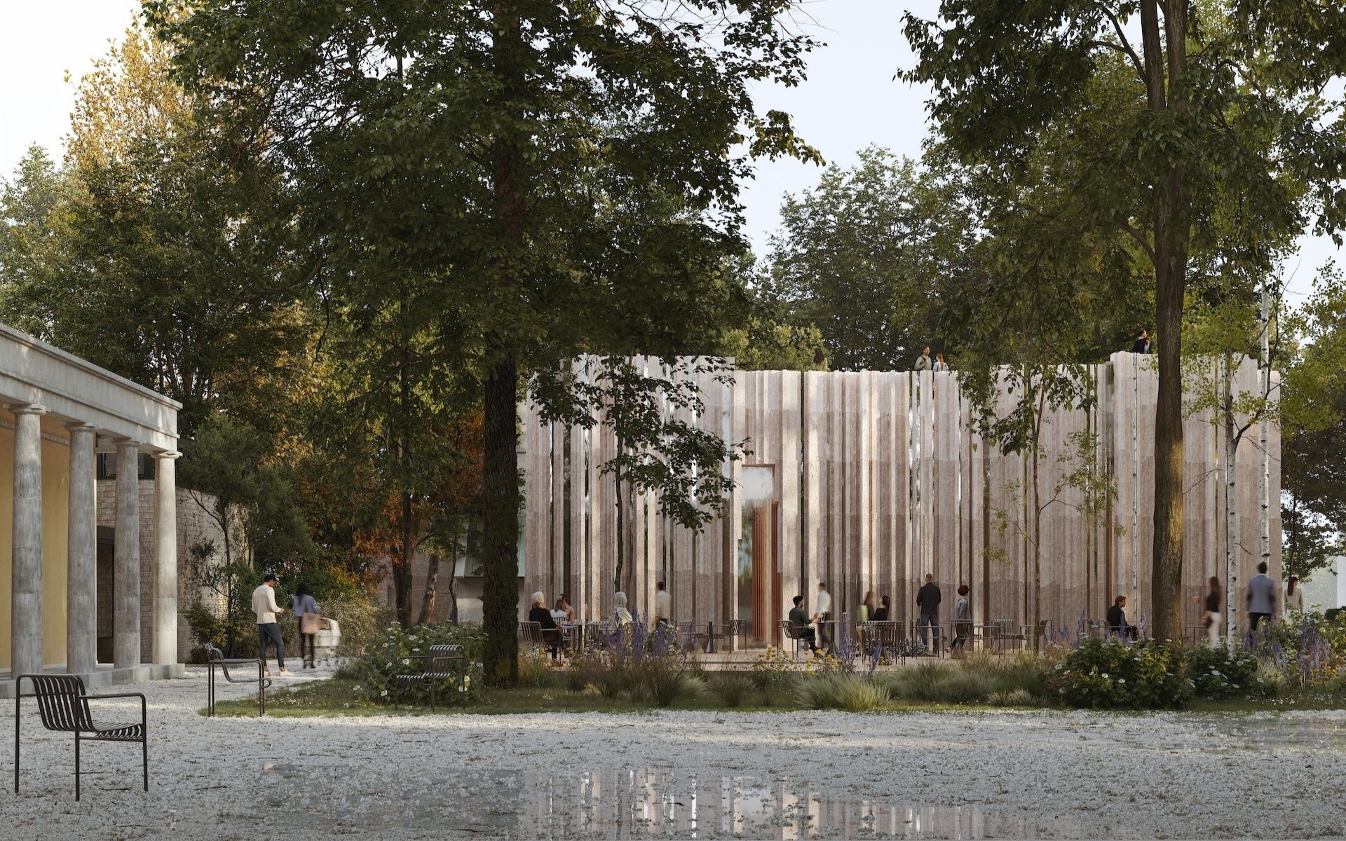 A modern wooden pavilion surrounded by trees and people, with a classical colonnade to the left, benches, and a gravel area in the foreground reflecting the sky.