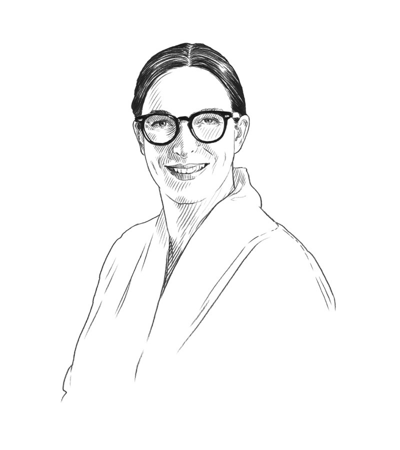 Black and white sketch of a smiling person with dark hair pulled back, wearing glasses and a collared shirt or coat, facing forward—perfect for profiles or features related to Q+A Qatar and Arts.
