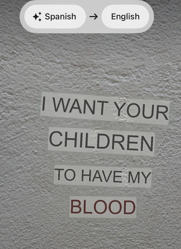 Text on a textured wall reads: I WANT YOUR CHILDREN TO HAVE MY BLOOD. At the top, a translation tool is set from Spanish to English.