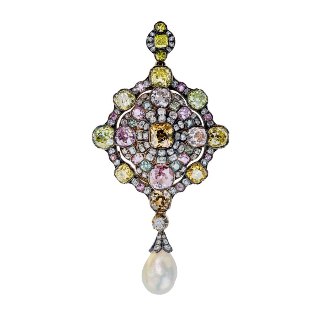 An ornate, diamond-shaped jewellery pendant featuring multi-colored gemstones and a single teardrop-shaped pearl dangling from the bottom.