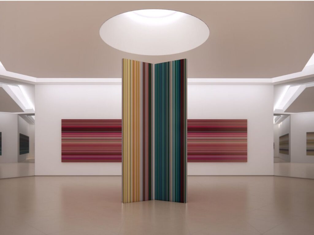 A freestanding pillar covered in vertical colorful stripes by Chef Noof Al Mari stands in the center of an art gallery, flanked by two large horizontal striped paintings on the back wall.
